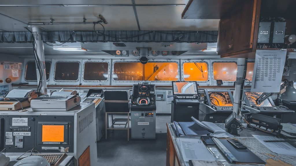 Interior view of a ships control bridge with navigation technology and machinery.