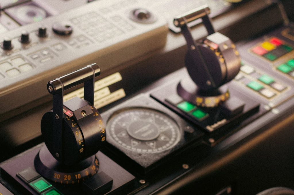 Detailed view of control levers and compass on a ships bridge, showcasing navigational technology.